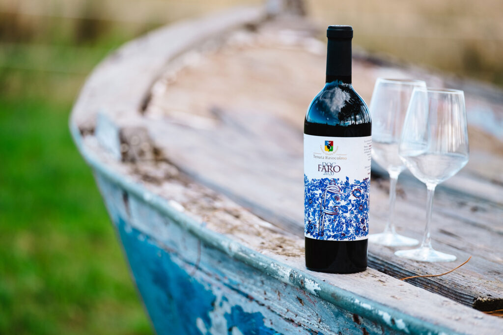 Una bottiglia di Faro DOC Rasocolmo annata 2020 con due calici di vino pronti per essere riempiti